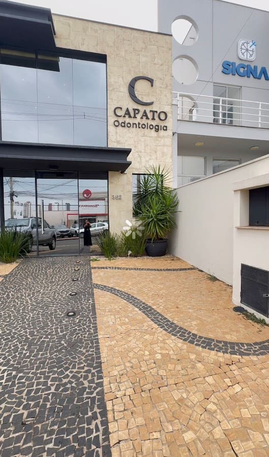 Foto da entrada da clínica odontológica, com boa iluminação e detalhes estéticos.